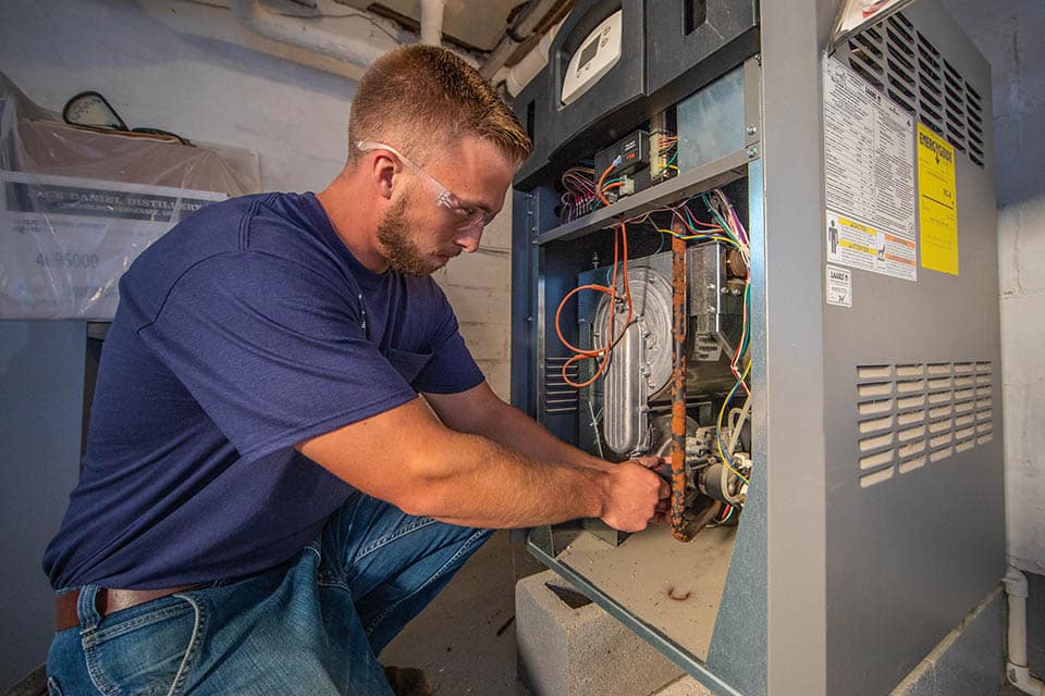 Service technician performing furnace repair service